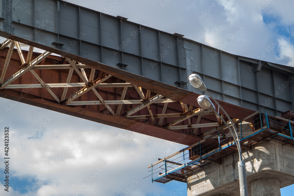 Naklejka premium close-up view of railway bridge under construction. connection of steel powerful straight crossbar, bridge connection, metal architecture