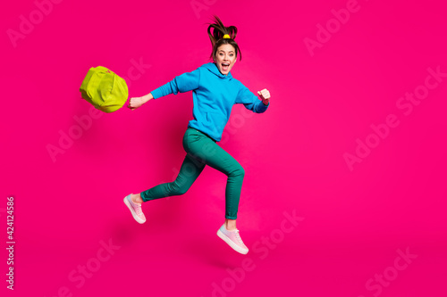 Full length photo of attractive young lady wear blue sweater holding schoolbag jumping running isolated pink color background