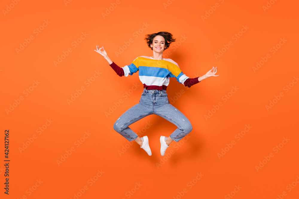 Full body photo of pretty lady jumping hands fingers meditate closed eyes isolated on orange color background