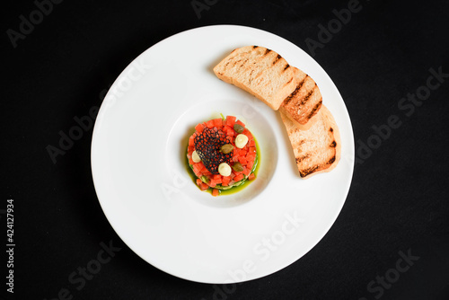 Close-up, the camera approaches a plate of tartare
