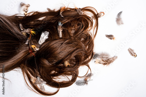 Hair mixed with feathers lie on a white table