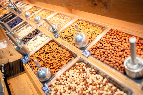 Many different nuts are sold on the counter in the store.
