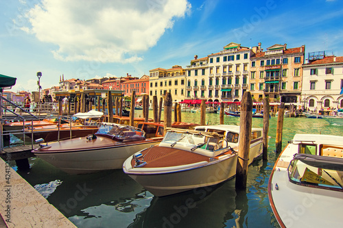 iew on the traditional boats, gondolas and colorful architecture near the ancient Rialto Bridge (Ponte di Rialto) in Venice, Italy. Soft focus