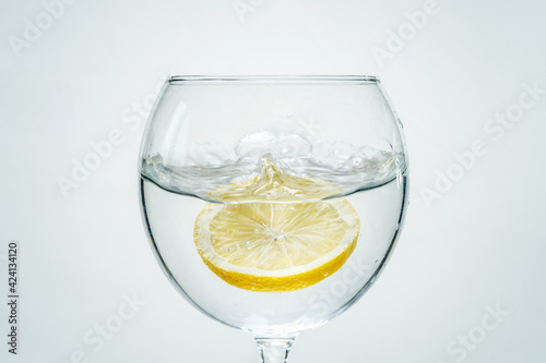 Fresh clear water with lemon and splashes on a white background