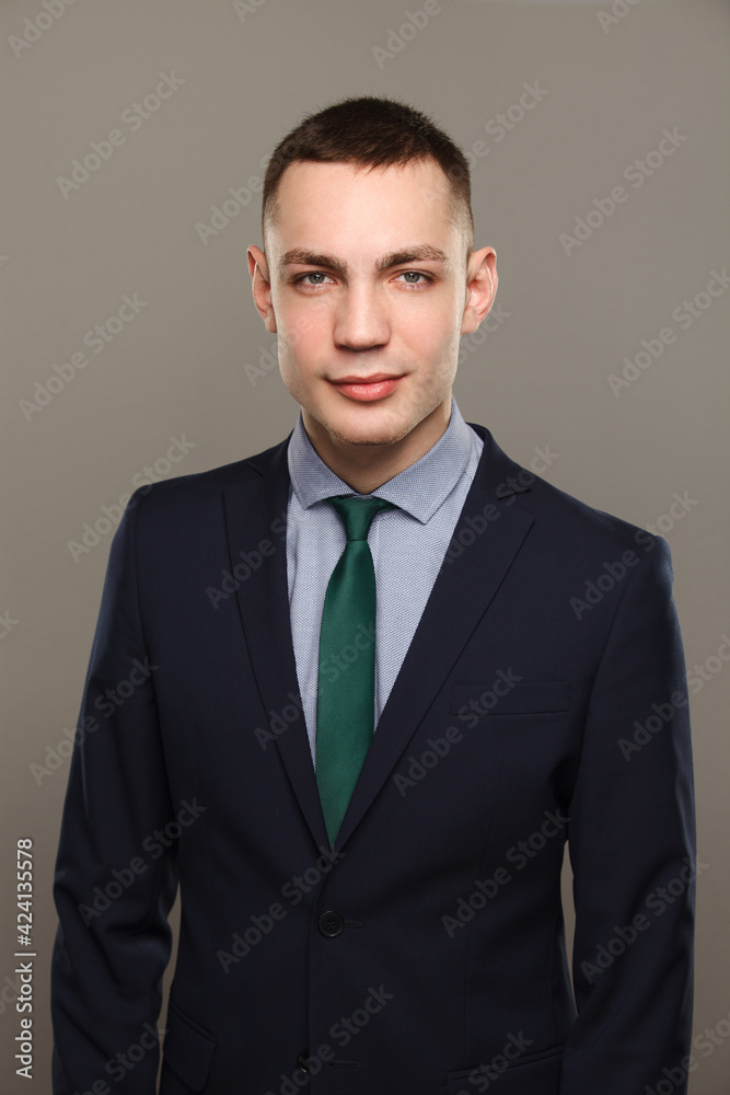 Businessman portrait in suite stands isolated over gray background. Studio shot Businessman portrait in suite stands isolated over gray background. Studio shot