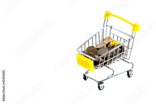 Coins inside a yellow shopping basket on a white background. Isolated.