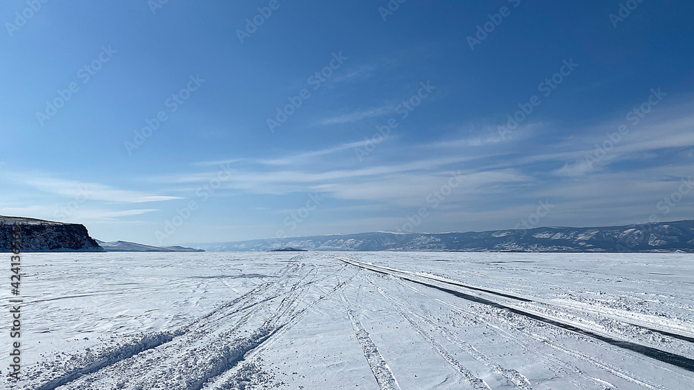 Frozen snow-capped Lake Baikal. Mountains, hills and endless expanses of Russia.