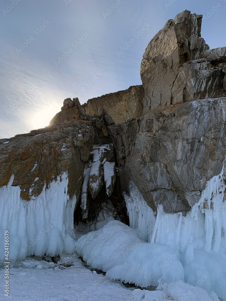 Lake Baikal grottoes. Ice cave on a frozen lake. Powerful rocky stones covered with ice and icicles.