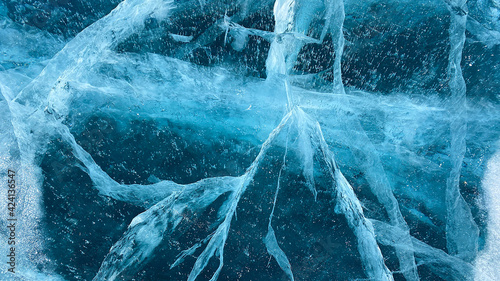 Amazing pattern of frozen winter lake Baikal. Blue transparent clear smooth ice with deep cracks. View from above.