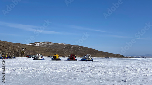 Fototapeta Naklejka Na Ścianę i Meble -  Four hovercraft bottom vehicles stand on the ice of frozen Lake Baikal.