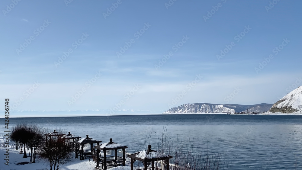 The non-freezing Angara River flows into the icy Lake Baikal. Northern landscape of frozen Lake Baikal