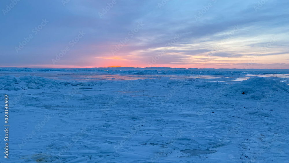 Fototapeta premium Amazing sunrise on the northern frosty Lake Baikal. Panorama of the northern landscape of the frozen lake.