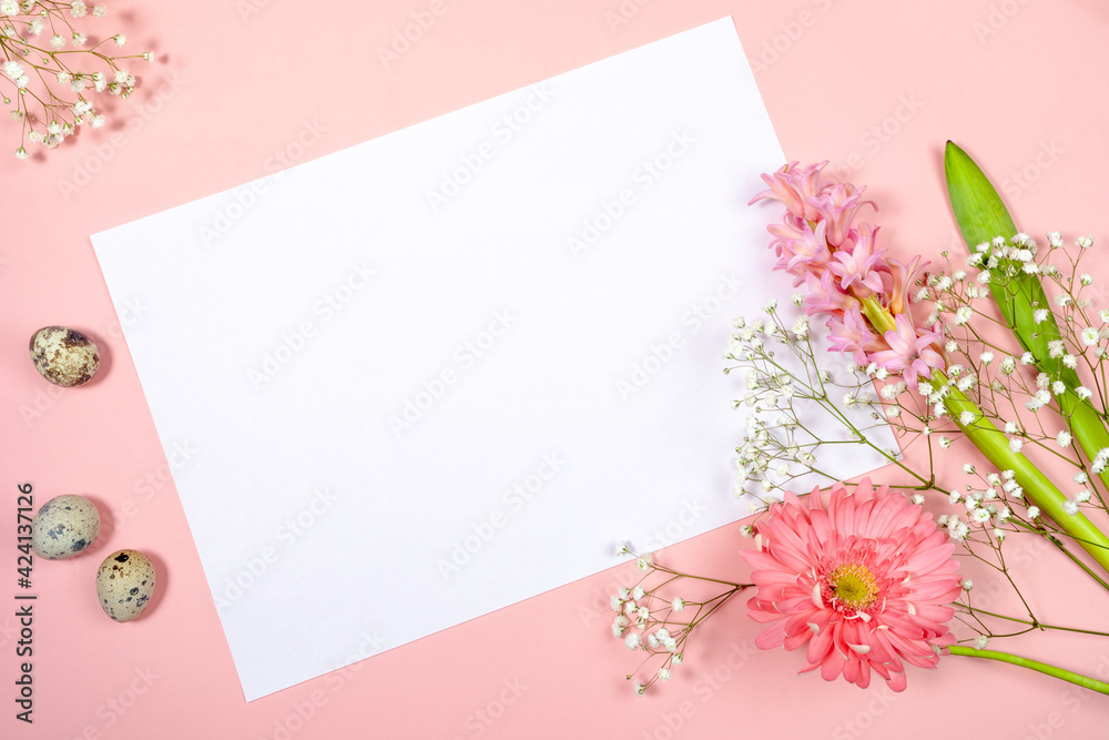 Easter festive greeting card with white sheet with copy space for text, quail eggs and spring flowers on pastel pink. Easter festive greeting card with white sheet with copy space for text, quail eggs and spring flowers on pastel pink.