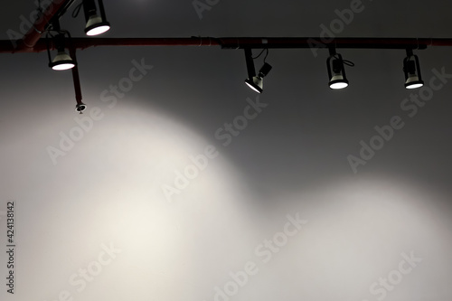 Hanging studio lights In the white room, the light shone all the space for text.