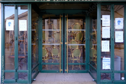 Some chairs stacked in front of a showcase of a closed Parisian cafe during the coronavirus pandemic. Paris the 29th march 2021.