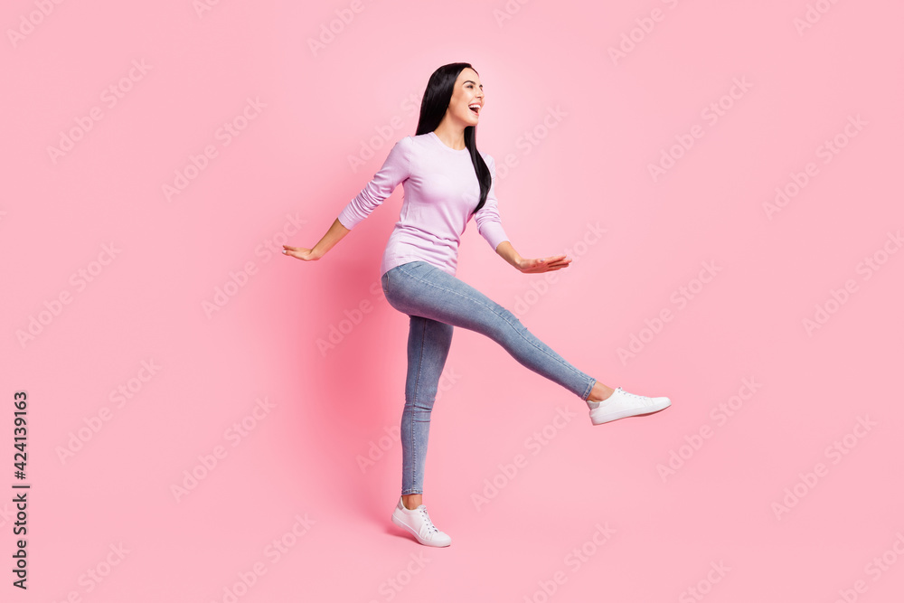Full size profile side photo of young beautiful smiling cheerful girl go walk look copyspace isolated on pink color background Full size profile side photo of young beautiful smiling cheerful girl go walk look copyspace isolated on pink color background