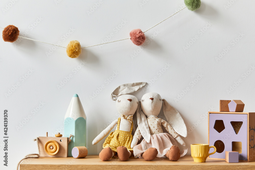 Stylish scandinavian newborn baby room with toys, plush animal, photo camera  and child accessories. Cozy decoration and hanging cotton balls on the  white wall. Copy space. Stock Photo | Adobe Stock