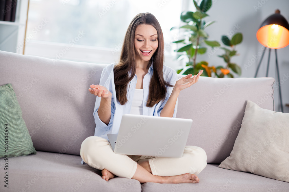 Full size photo of nice optimistic brunette long hairdo lady sit talk laptop on coach wear blue shirt at home Full size photo of nice optimistic brunette long hairdo lady sit talk laptop on coach wear blue shirt at home