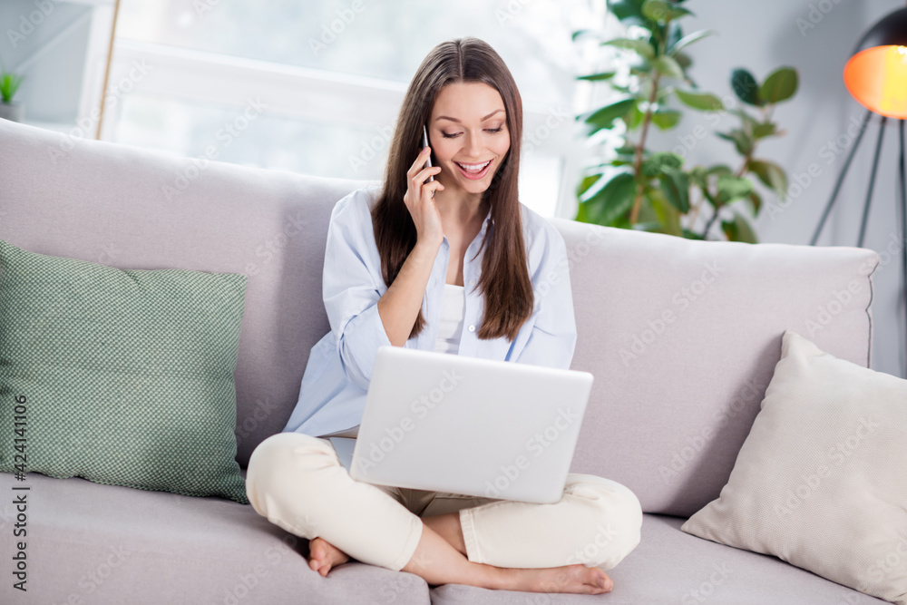 Full size photo of nice optimistic brunette long hairdo lady sit look telephone laptop on coach wear shirt at home Full size photo of nice optimistic brunette long hairdo lady sit look telephone laptop on coach wear shirt at home