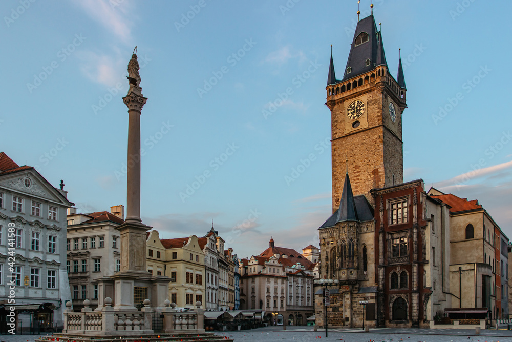 Fototapeta premium Old Town Square in Prague, Czech Republic. Empty city during sunrise without people surrounded by historical, gothic style buildings and the famous Astronomical Clock Tower.Beautiful urban scene
