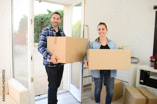 happy young couple moving carboard boxes and furnitures during move into a new home flat apartment © W PRODUCTION