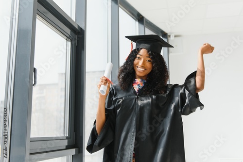 cheerful african american graduate student with diploma in her hand