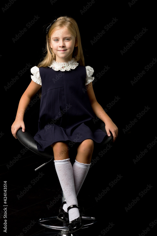 Lovely girl in school uniform sitting on chair Stock Photo | Adobe Stock