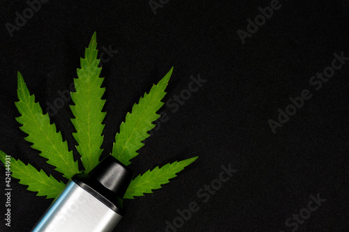 electronic vaporizer for smoking with cannabis leaf on black background