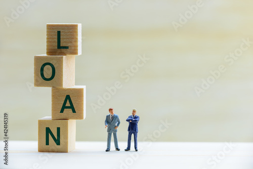 Financial loan negotiation / discussion among a lender and borrower concept : Miniature figurine two businessmen talk on money loan contract agreement, discuss about a company credit and loan profile photo