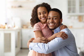 Loving black family father and daughter hugging