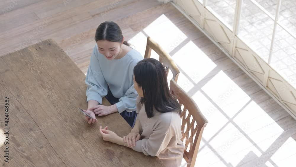 スマホを見せる女性　親子　相談