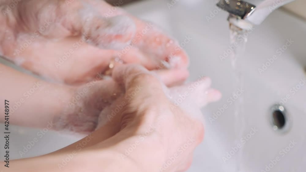 Mother with little son washing hands together. Protection and disinfection against coronavirus. Mom helps her child wash their hands with soap over the sink at home. Concept of health and hygiene. Mother with little son washing hands together. Protection and disinfection against coronavirus. Mom helps her child wash their hands with soap over the sink at home. Concept of health and hygiene.