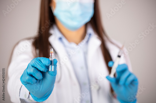 Doctor, researcher or scientist hand in blue glove holding flu, measles, rubella or hpv vaccine and syringe with needle vaccination for baby, child, woman or man shot, medicine vial dose injection
