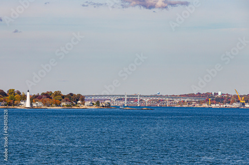 view to coast of New London on a sunny day with lighthouse and bridge