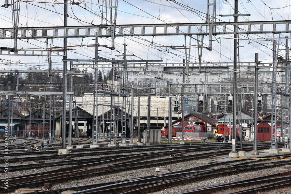 Railway depot with parked trains in Winterthur, Switzerland with a lot of railway electric pillars and power lines Railway depot with parked trains in Winterthur, Switzerland with a lot of railway electric pillars and power lines