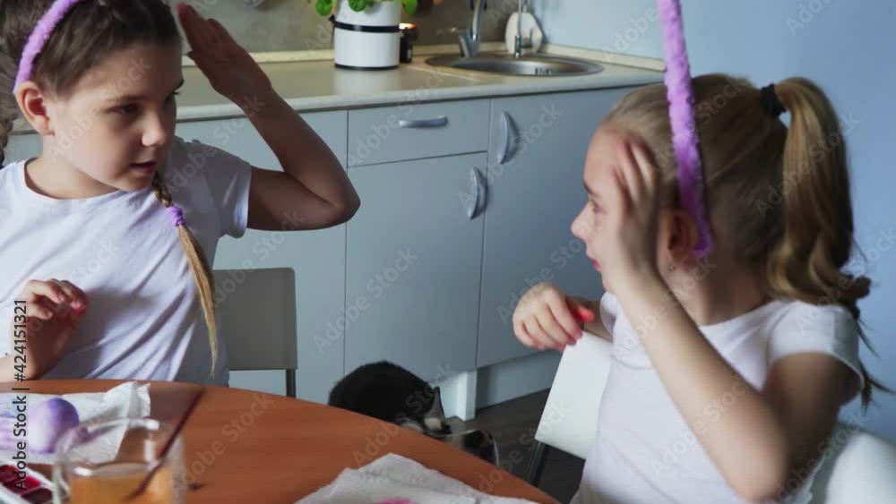 Happy family preparing for Easter. Cute little girl wears a pink bunny ears on her sister