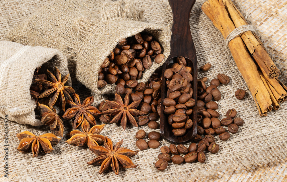 roasted coffee beans with spices with cloth bag on wood texture