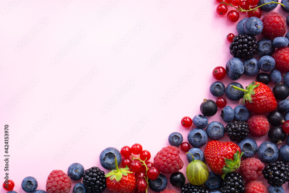 Various fresh summer berries. on pink background . with copy space. Top view Various fresh summer berries. on pink background . with copy space. Top view