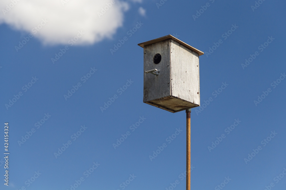 Wooden birdhouse against the sky, do-it-yourself birdhouse, house for birds Wooden birdhouse against the sky, do-it-yourself birdhouse, house for birds