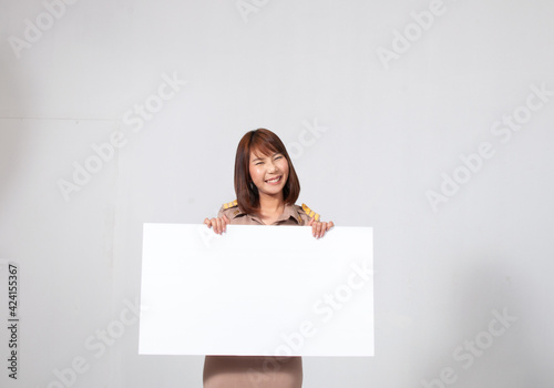 Female thai teacher in uniform standing with white background holding big white paper