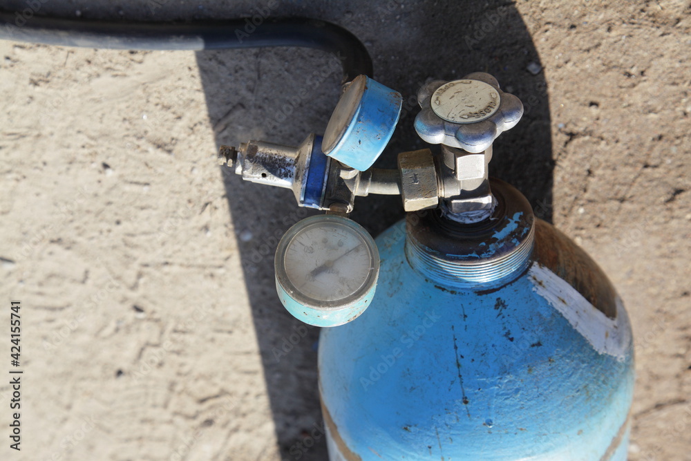 Blue Oxygen cylinder with faucet valve and manometers appliances closeup, metal gas cutting Blue Oxygen cylinder with faucet valve and manometers appliances closeup, metal gas cutting