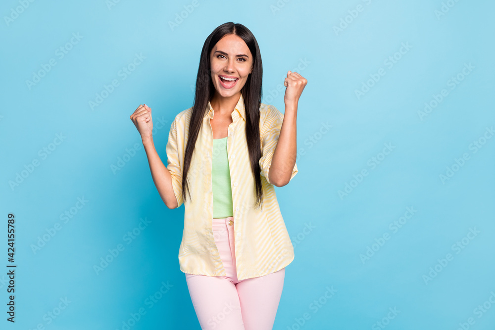 Photo of astonished positive lady fists up open mouth scream yeah celebrate isolated on blue color background
