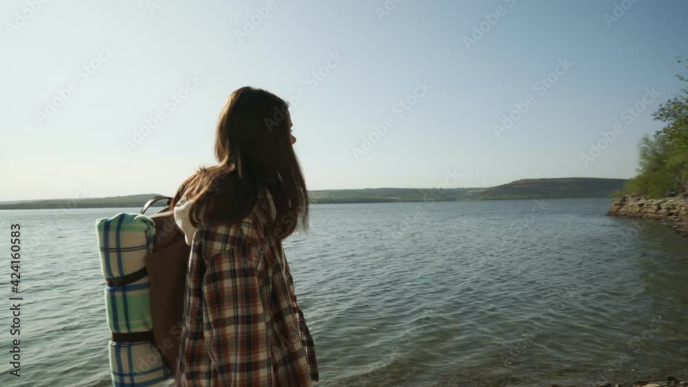 Woman with backpack walking on riverside of Bakota bay Woman with backpack walking on riverside of Bakota bay