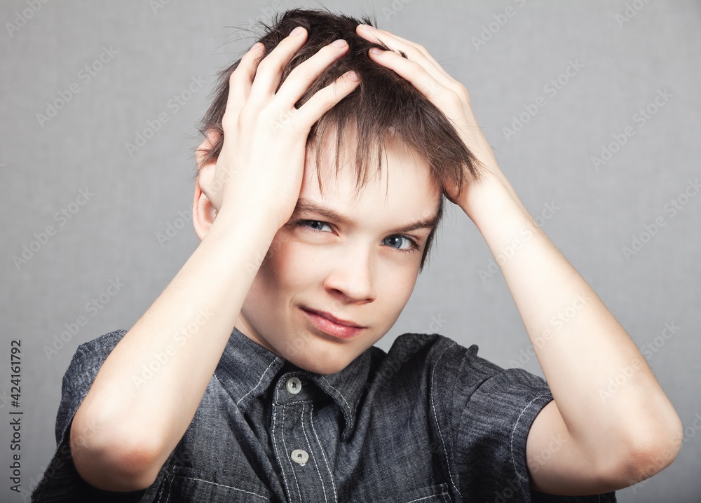Child holding his head suffering from headache Child holding his head suffering from headache