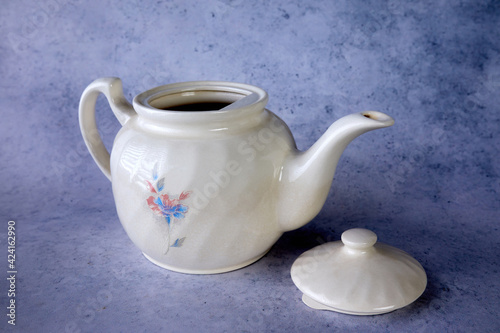 an old teapot with a floral pattern