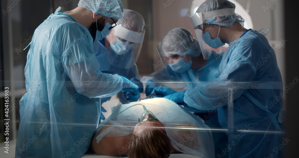 Medical team performing surgical operation in modern operating room ...