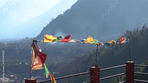 Slow motion shot of colorful Buddhist Bhutanese Tibetan prayer flag in front of mountains at Pangan Nyingma Monastery in Patlikuhal village near Manali, Himachal Pradesh, India