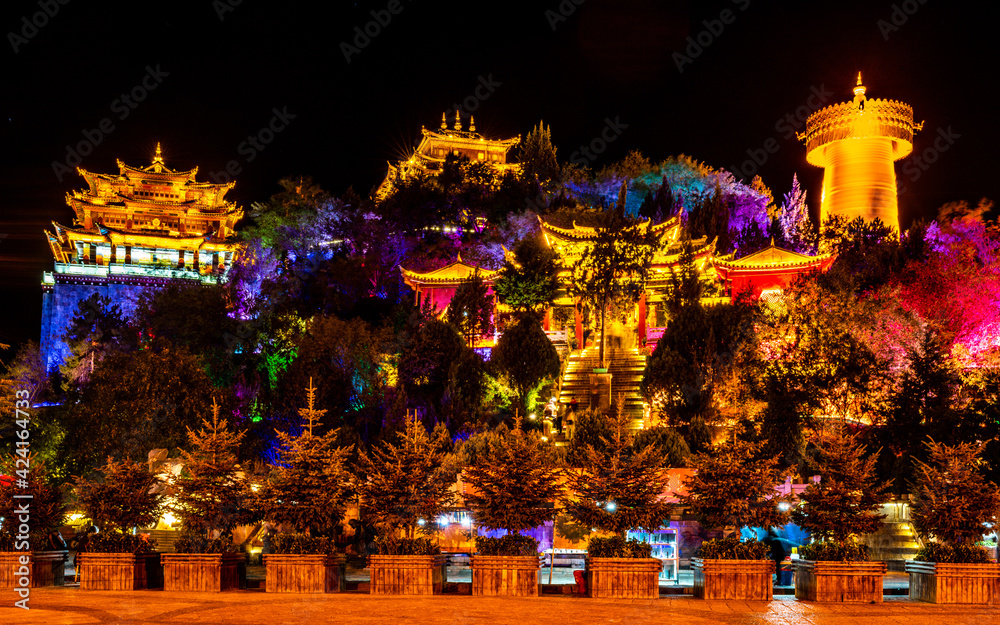 Fototapeta Guishan Dafo Big Buddha temple colourfully illuminated at night long exposure wide angle shot Shangri-La Yunnan China