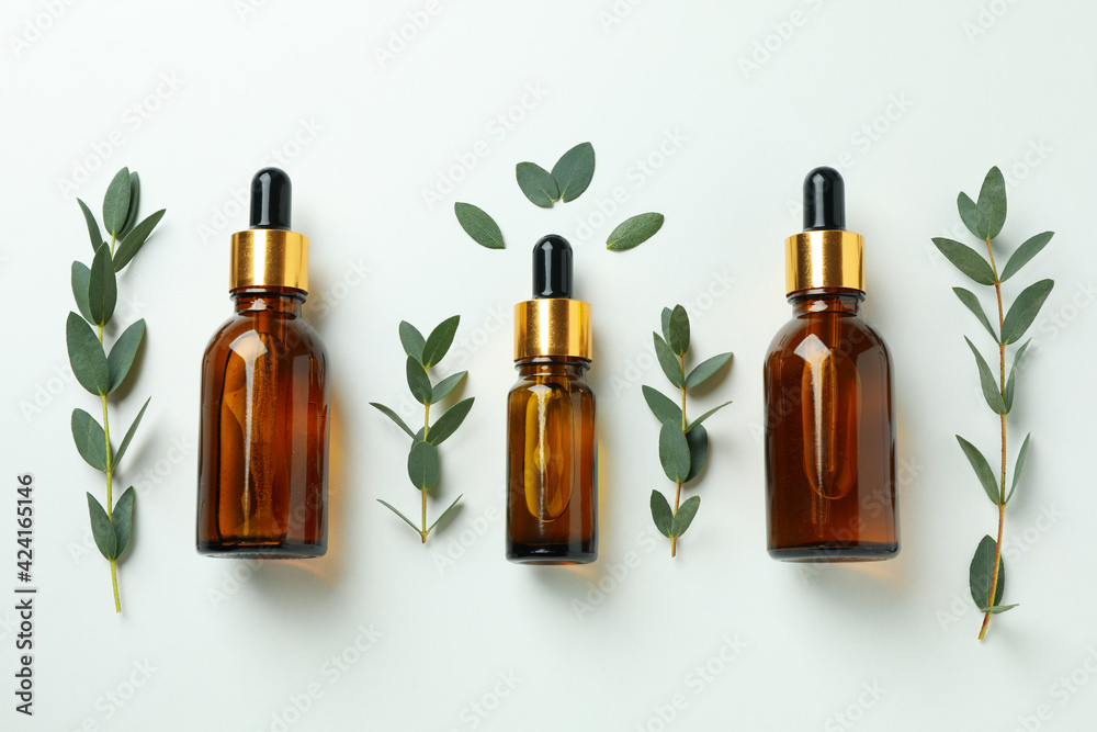 Brown bottles of eucalyptus oil and twigs on white background Brown bottles of eucalyptus oil and twigs on white background