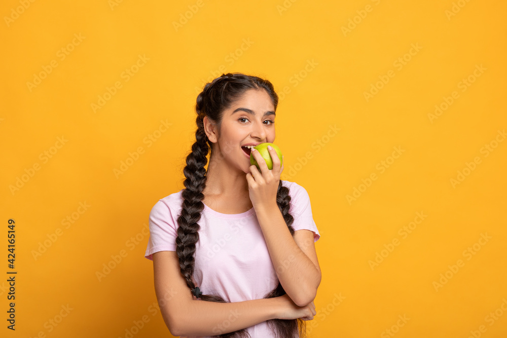Portrait of a cheerful young woman eating green apple Portrait of a cheerful young woman eating green apple